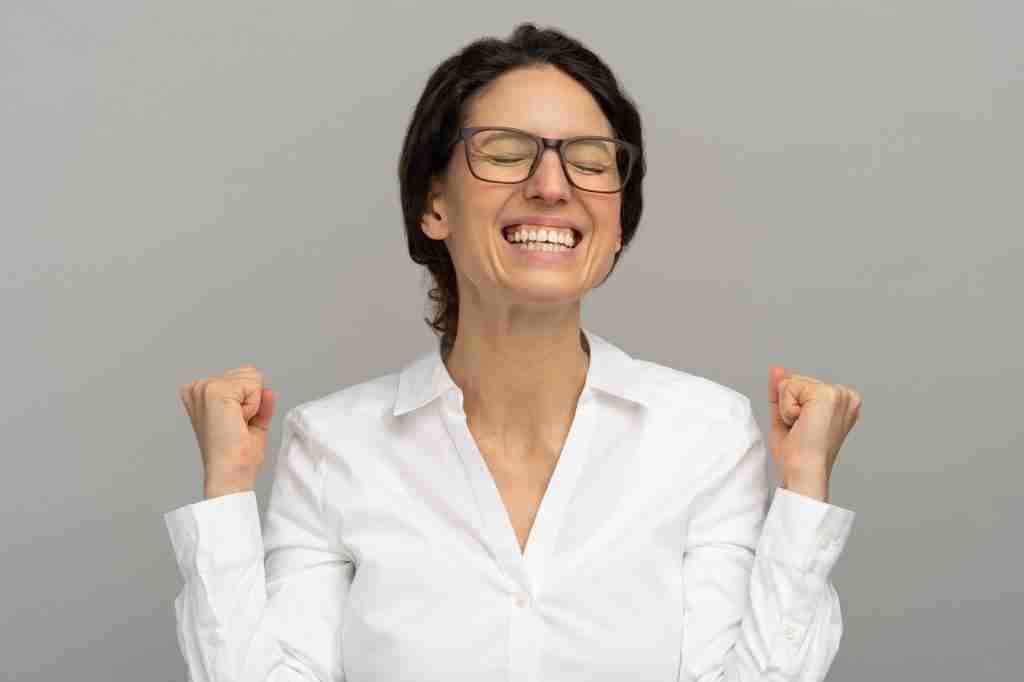 Happy winning successful office worker raising fists celebrates career ladder promotion or reward