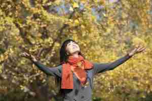 Happy young woman appreciating the golden autumn