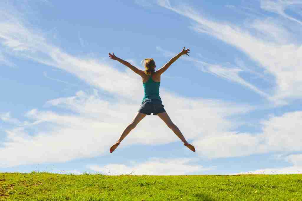 Happy woman jumping for joy, celebrating winning and enjoying happiness of freedom and carefree life